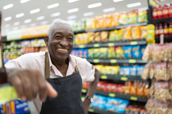 Smiling employee in grocery store aisle
