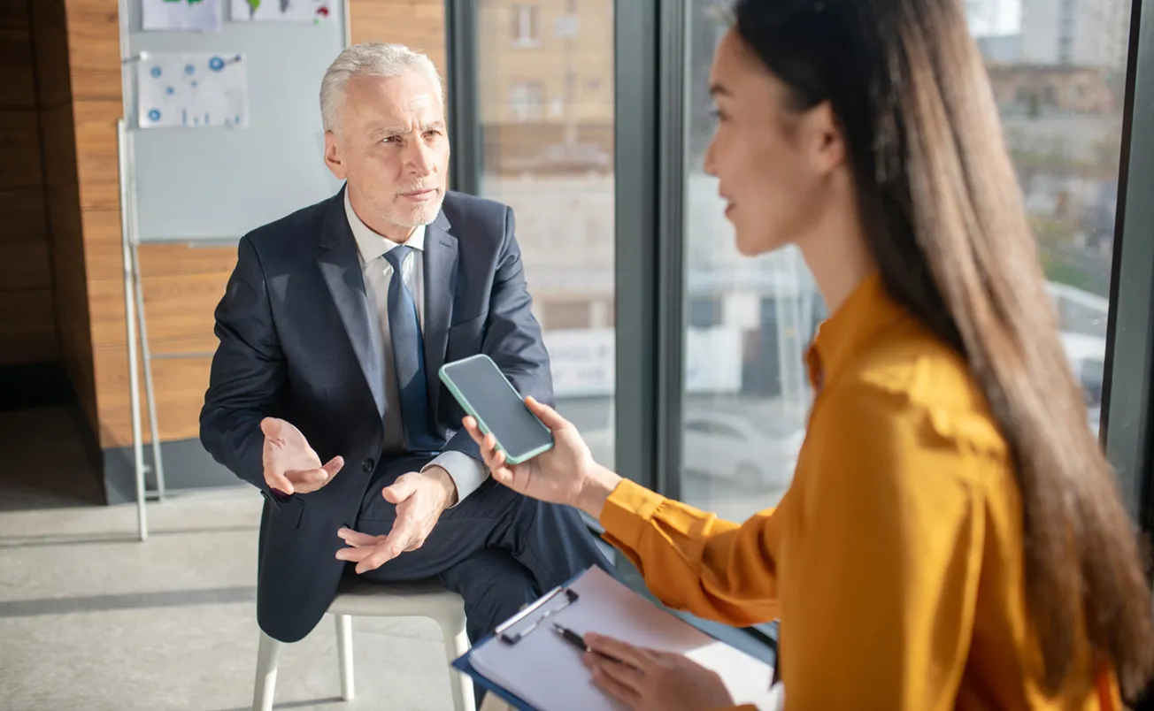 Female reporter with long hair looking busy during interview stock photo