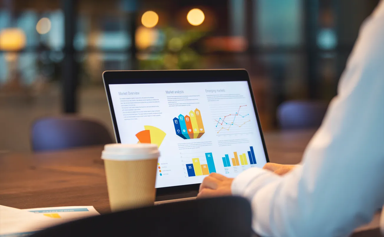 Close up of businessman using a laptop with graphs and charts on a laptop computer