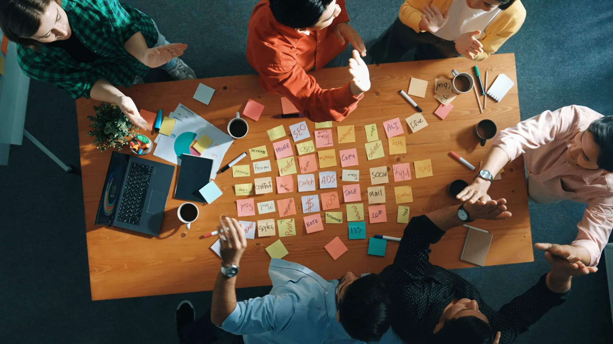 Top down view of business people writing marketing idea at meeting