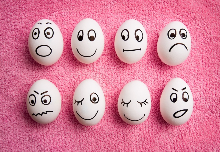 Eggs with faces representing various emotions drawn on them on a pink background to represent various sentiments that consumers express in customer feedback.